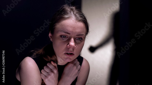 Cuadros en Lienzo Frightened female victim crying, serial maniac silhouette entering room, fear