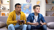 Excited multiethnic teen friends enjoying video games, free time at home