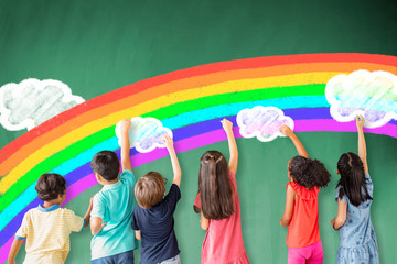 Wall Mural - school children drawing rainbow and cloud on the chalkboard