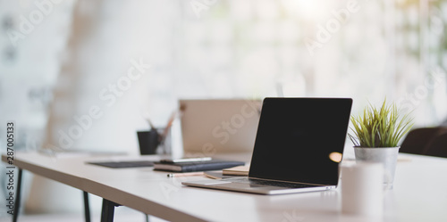 Fotografía Open blank laptop in modern workplace with office supplies and decorations