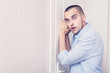 © Анастасия Семашко - Young attractive man eavesdropping on someone outside the door, portrait, toned, copy space