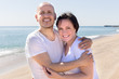© caftor - man and a middle-aged woman in white T-shirt on the beach