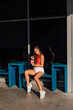 © Smile - Stylish happy young brunette woman wearing white shorts and sneakers holding pink cup of coffee to go.