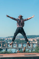 the man jumping with happiness. beautiful view of the old city of Prague, Praha, tourist tour in Europe, vacation. having fun.