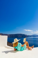 Wall Mural - Luxury travel vacation woman looking at view on Santorini island