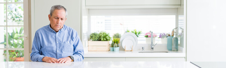 Sticker - Wide angle perspective of handsome senior man at home depressed and worry for distress, crying angry and afraid. Sad expression.