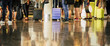 © simona - group of people waiting at their flight at the airport - travel concept with passengers waiting to enter at the gate or check-in with their baggage -unrecognizable and mirrored on the floor