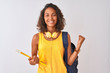 © Krakenimages.com - Brazilian student woman wearing backpack holding notebook over isolated white background screaming proud and celebrating victory and success very excited, cheering emotion