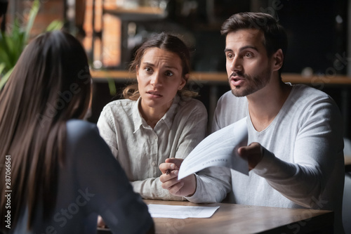 Angry couple arguing with bank manager complain on bad contract Poster Mural XXL