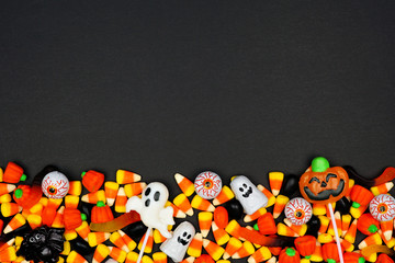 Poster - Halloween candy bottom border. Top view on a black background with copy space.