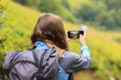 © Андрей Репетий - Hiker woman taking smart phone photo in mountain valley enjoying beautiful nature landscape.