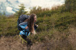 © Андрей Репетий - Woman hiker with backpack climbing the hill. Self improvement and life goals concept.