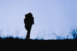 © Андрей Репетий - Silhouette of a woman hiker climbing a mountain.