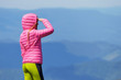 © Андрей Репетий - Slim girl in a pink coat looking into the distance in the mountains.