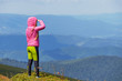 © Андрей Репетий - Young girl hiker enjoying a beautiful nature of mountains standing on the peak of mountain.