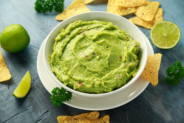 Wall Mural - Bowl of fresh Guacamole with nachos chips and herbs. Healthy Vegan, Vegetables food.