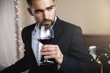 Handsome bearded man with a glass of red wine