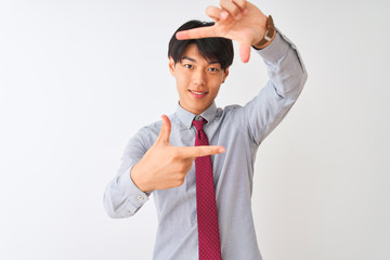 Chinese businessman wearing elegant tie standing over isolated white background smiling making frame with hands and fingers with happy face. Creativity and photography concept.