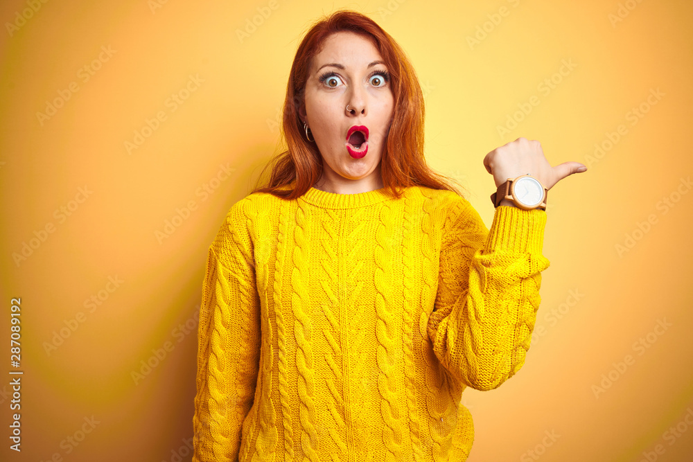 Beautiful redhead woman wearing winter sweater standing over isolated