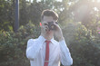 © f2014vad - Stylishly dressed young man sits taking pictures in the park. In his hands holds a SLR film camera.