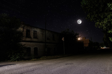 Wall Mural - full moon over quite village at night. beautiful night landscape of old town street with lights. rus