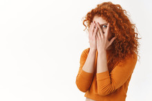Flirty Cute Redhead Sly Woman With Curly Long Hairstyle, Hiding Face Behind Palms, Peeking One Eye Through Fingers Curiously Check Out Promo, Intrigued What Happening, Stand White Background