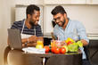 © liliyabatyrova - Two men using laptop in kitchen