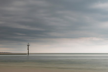 Beautiful Landscape Image Of Beach At Low Tide With Dramatic Storm Clouds Gathering Overhead