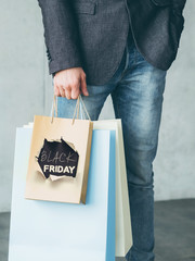 Wall Mural - Black friday. Consumerism discount offer. Male shopaholic with paper bags.