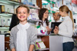 Little glad girl in the pharmacy with parents and pharmacist