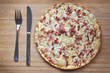 Top view of taditional food `Tarte Flambee` or `Flammkuchen` from German-French Alsace border region. The name means `pie baked in the flames`, similar to a thin pizza with bacon and soured cream