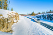 Winter journey. Bus transportation on the winter road. Road safety. Bus on the road. Snow-covered rocks and pines across the road. Trip to Karelia. Stay in the fresh air.