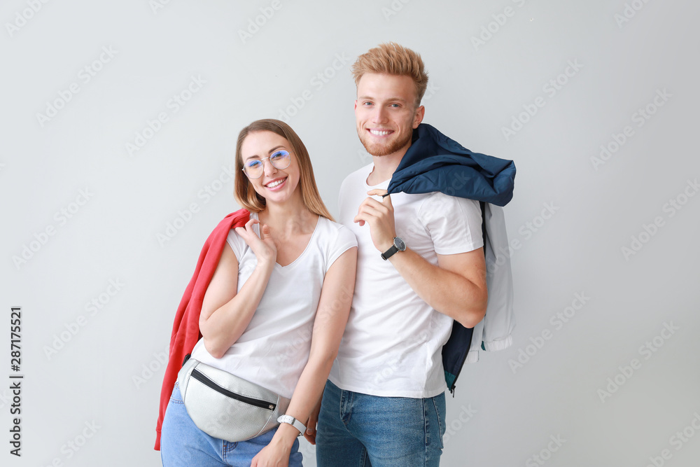 Couple in stylish t-shirts on light background