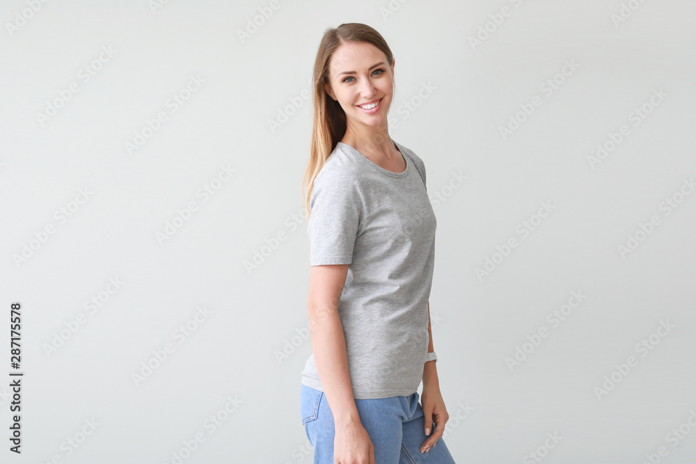 Woman in stylish t-shirt on light background