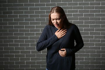 Wall Mural - Woman having panic attack against brick wall