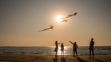 Friendly Family Plays With Kites On The Seashore.