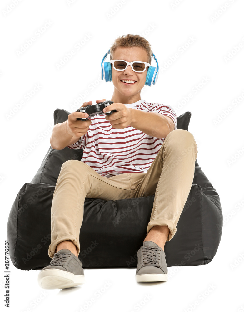 Teenage boy playing video game on white background