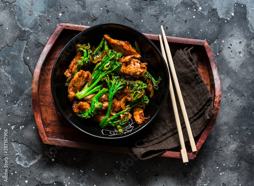 Cuadros en Lienzo Teriyaki stir fry chicken with broccoli on wooden tray on dark background, top v