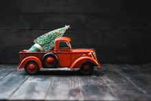 Red Toy Truck With A Christmas Tree On A Dark Wood Background
