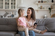 © fizkes - Cheerful daughter sitting on mother lap enjoy online education programs