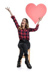 Poster - casual woman sitting with a heart full of excitement