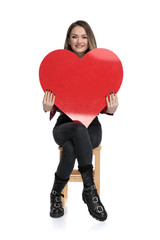 Poster - casual woman sitting with a big heart on hands