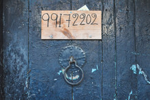 Old Wooden Door With A Number  Under A Door Knob. Texture Background