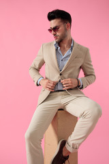 Canvas Print - attractive young man fixing his coat sitting on a wooden box