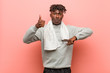 © Asier - Young fitness african black man showing thumbs up and thumbs down, difficult choose concept