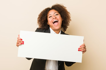 Wall Mural - Young african american woman holding a placard celebrating a victory or success