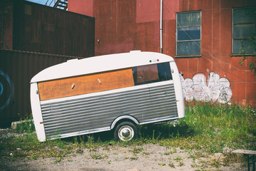 Old trailer for street food, against the background of old city buildings. Stylized retro