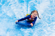 Little Girl Surfing In Beach Wave Simulator