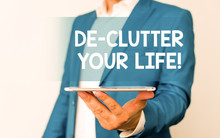 Handwriting Text De Clutter Your Life. Conceptual Photo Remove Unnecessary Items From Untidy Or Overcrowded Places Man In The Blue Suite And White Shirt Holds Mobile Phone In The Hand