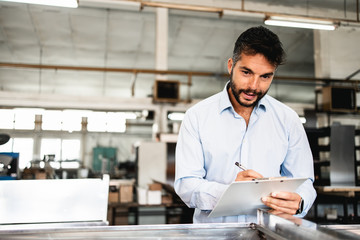 Middle age businessman doing quality control checking at industry production. Factory for industrial production of electric housings and surge arresters.